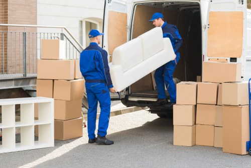 Moving crew handling furniture during a van removal service
